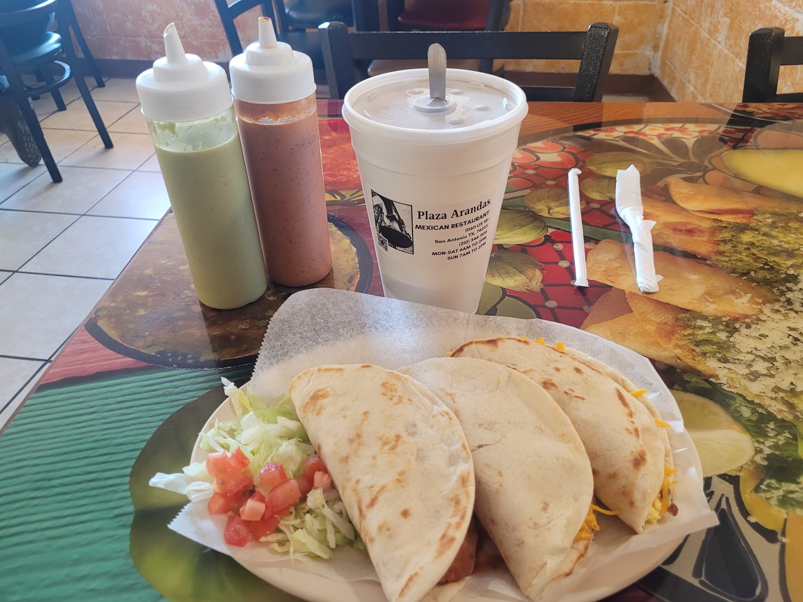 Bacon and egg breakfast tacos with fresh salsas in a Plaza Arandas cup