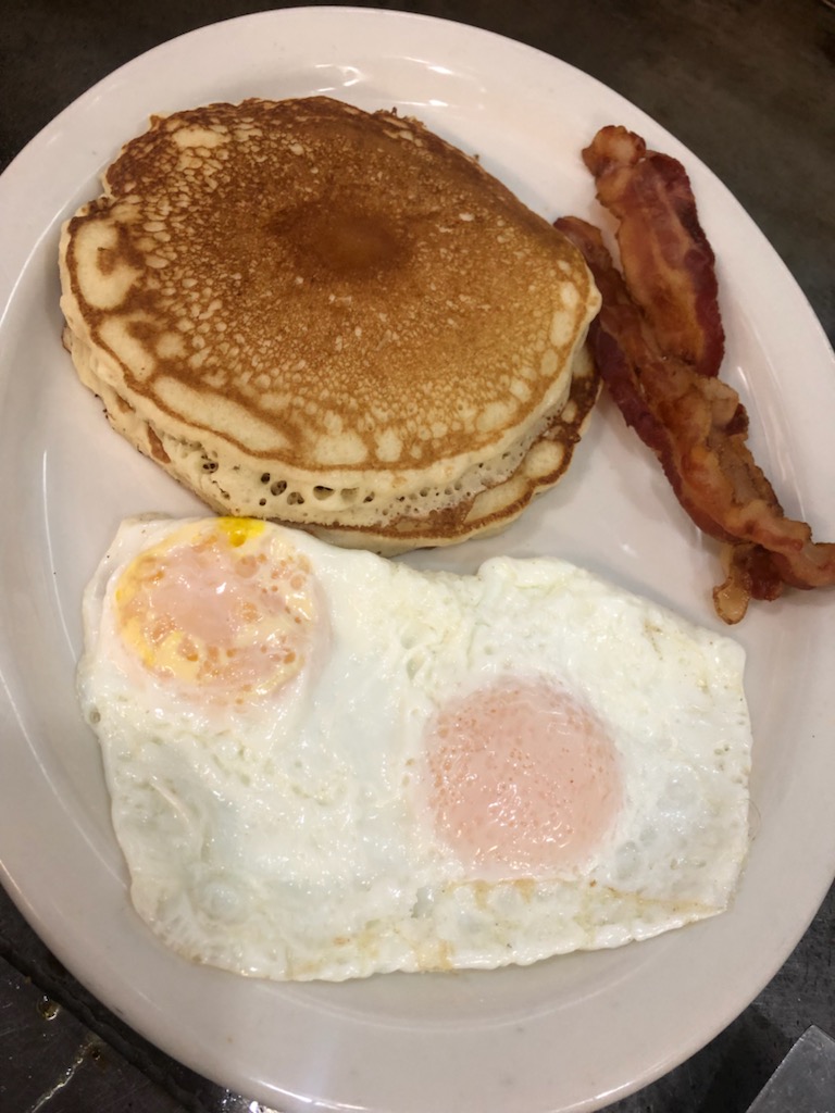 Buttermilk pancakes with bacon and fried eggs
