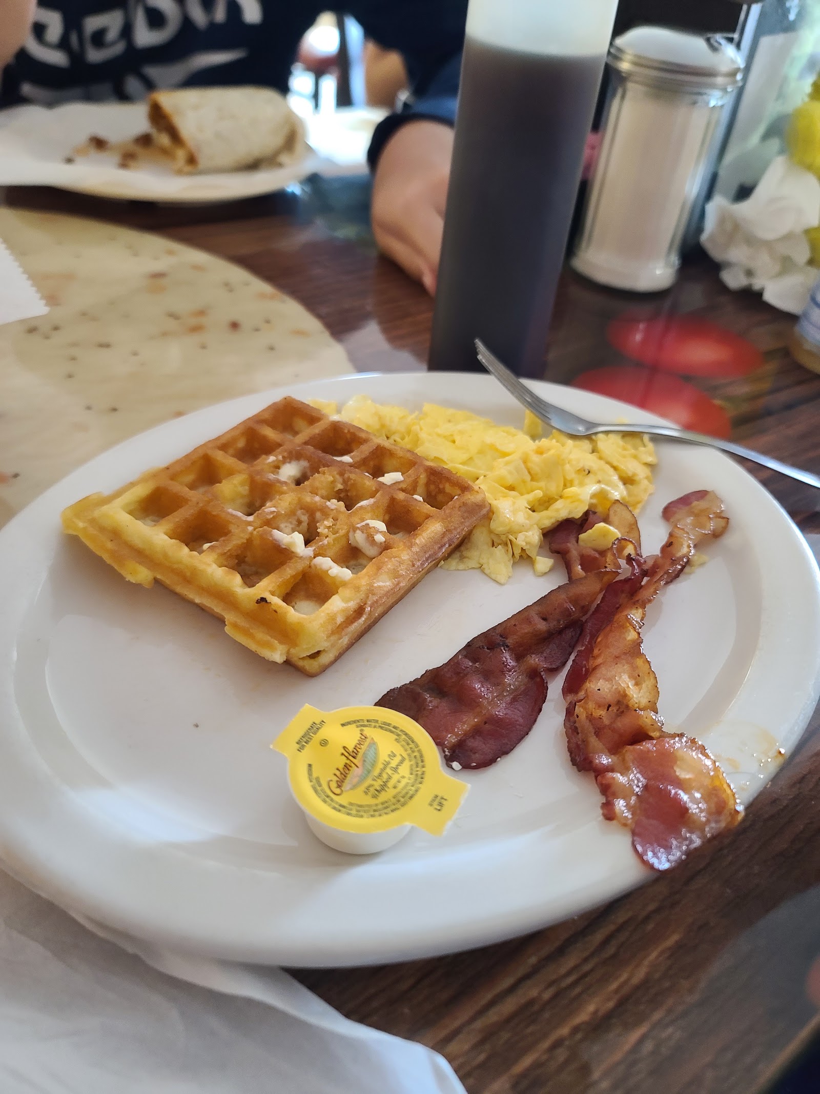Waffle plate with scrambled eggs and crispy bacon